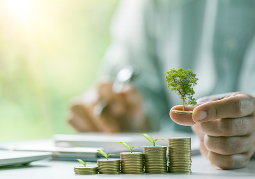 Ambiente de escritório com moedas empilhadas de forma a parecer um gráfico ascendente